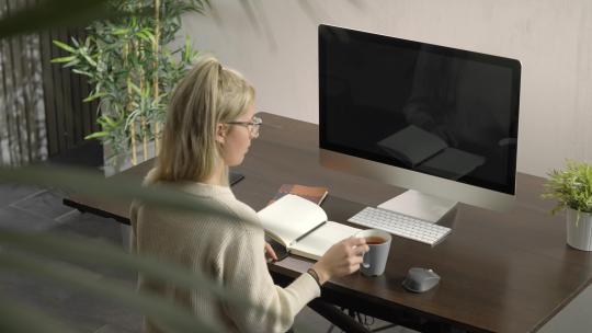 女性远程学习课程做远程工作概念在家办公室工作和喝一杯视频素材模板下载