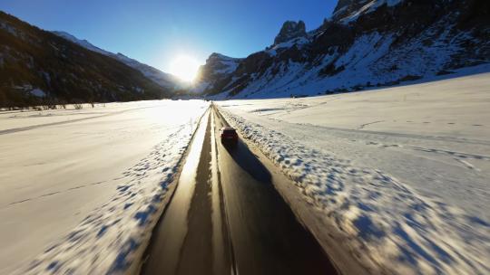 FPV无人机航拍冬日汽车行驶在雪地中的公路