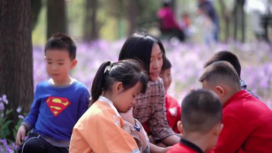 幼儿教师在花丛中给孩子们讲故事