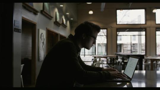 男人坐在咖啡厅用电脑办公