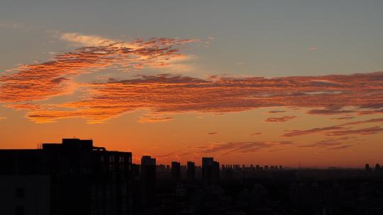 日出前北京城市上空的彩云