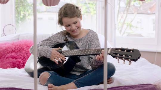 女孩在床上弹吉他