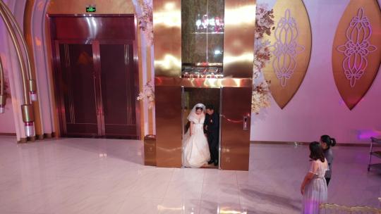婚礼中的新娘和父亲下电梯进会场