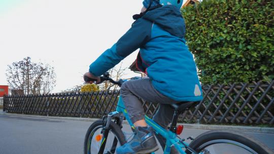 小男孩在街道上骑着自行车视频素材模板下载