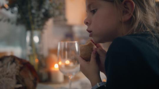女孩儿在餐桌上吃面包卷视频素材模板下载