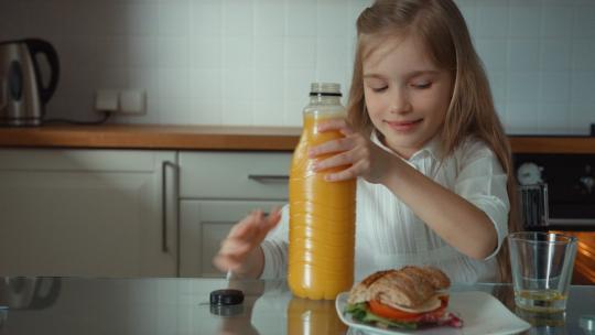女孩把橙汁倒进杯子视频素材模板下载