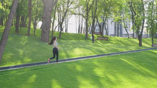 绿色公园中的女性慢跑者视频素材模板下载