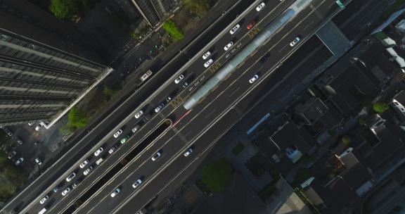 旋转俯拍城市高楼下街道路密集汽车行驶车流