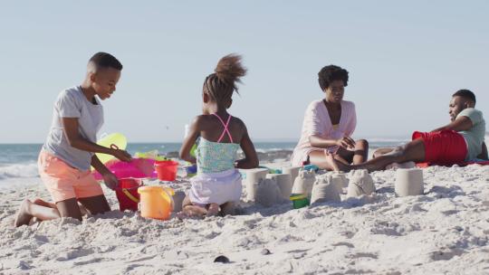 快乐的非裔美国孩子和父母在海滩上玩耍的视频视频素材模板下载