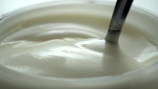 在杯子里用勺子搅拌酸奶的慢动作！