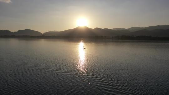 傍晚夕阳湖面上划浆板