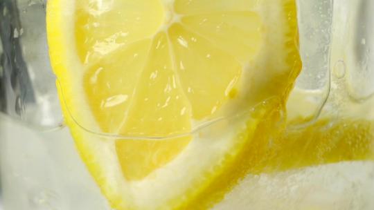 黄色的柠檬水加冰块特写镜头慢动作