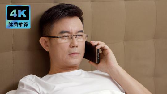 男子在床上打电话手机通话使用手机