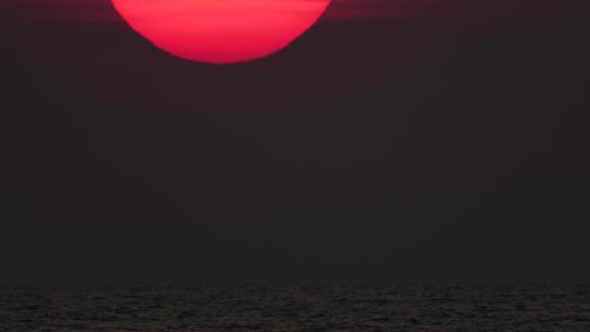 巨大的红色太阳从地平线上落下延时太阳