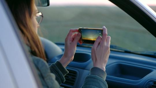 女孩从车里拍日落照片视频素材模板下载