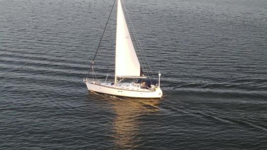 美国路易斯安那州新奥尔良市庞恰特雷恩湖平静海水中帆船巡航的人。