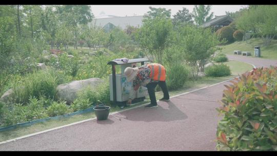 公园里环卫工人在擦垃圾箱视频素材模板下载
