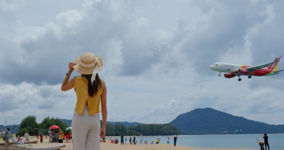 奈杨海滩，游客在海滩上看飞机