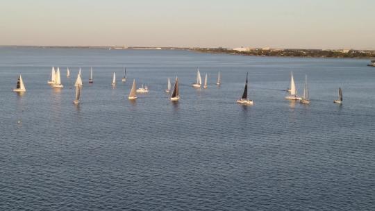 阳光明媚的一天，小艇漂流在路易斯安那州新奥尔良的庞恰特雷恩湖上。无人驾驶飞机轨道