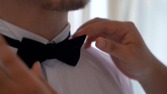 妻子给丈夫系领带女人给男人系领带整理衣服视频素材模板下载