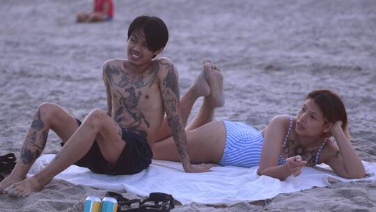 一对情侣在沙滩上放松聊天