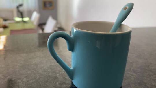 一个带勺子的蓝色陶瓷杯的特写镜头