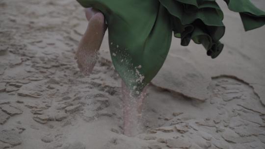 穿着优雅优雅的绿色连衣裙的女人的脚走着思想沙丘沙漠小山到山顶