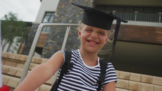 快乐的高加索女孩戴着毕业帽拿着文凭的视频