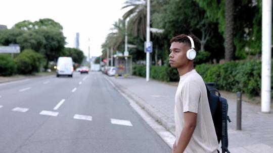 西班牙裔拉丁青少年男孩一边听音乐一边在户外散步