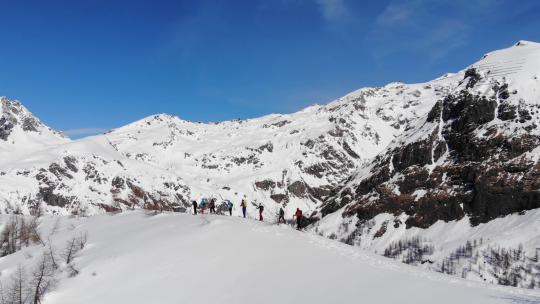 一组滑雪旅游在皮肤上坡排成一行。在大山里滑雪旅游