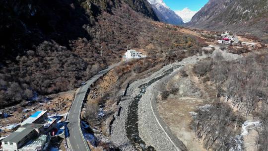 航拍四姑娘山双桥沟雪山下的藏式村寨民居