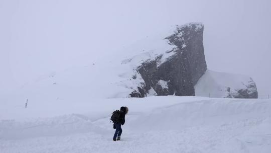 登山者风雪中孤独行走徒步攀登