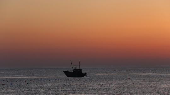 烟台大海黄昏日落，夕阳海边行走的女孩