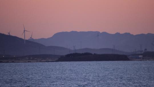 黄昏时分的威海双岛湾大岛和远山风电