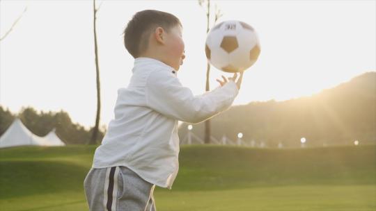 小男孩踢足球户外锻炼童年时光欢乐快乐家庭