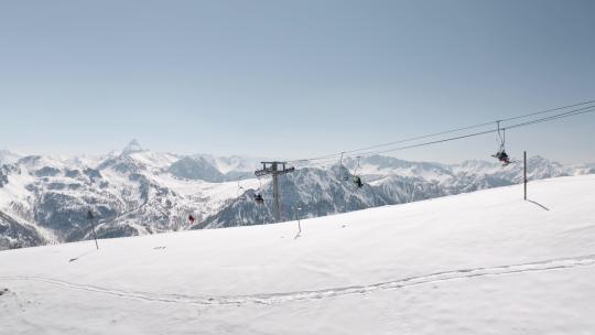冬天无人机在山上拍摄的滑雪缆车，滑雪者在上面