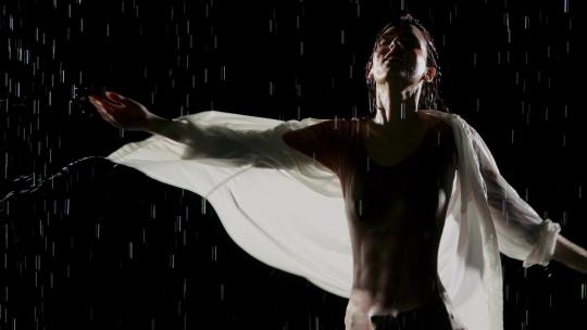 美丽的女人在雨中跳舞
