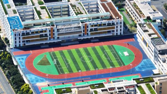 航拍城市教育用地校园教学楼与足球场