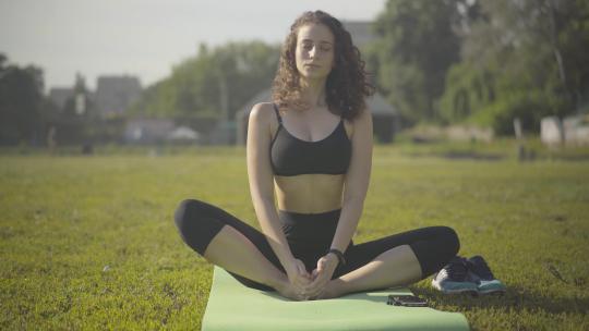 女性在运动垫上练瑜伽视频素材模板下载