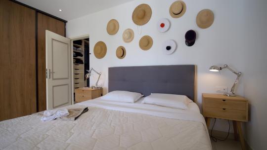 一张双人床和墙上的草帽