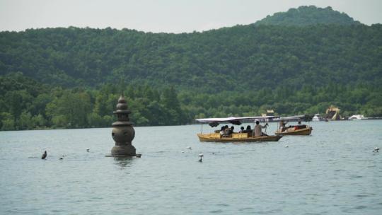游客划船在西湖三潭印月游玩
