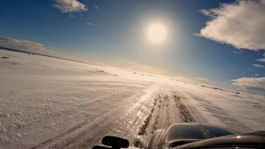汽车行驶在雪地上冬日冬季雪景日出日落晚霞