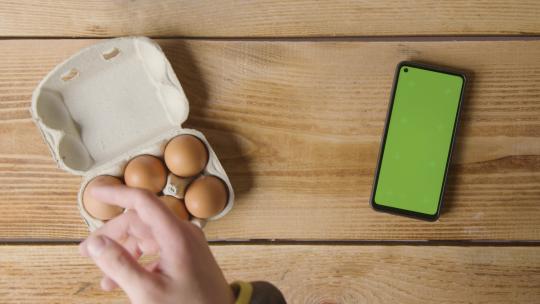 桌面上的红皮鸡蛋绿屏手机