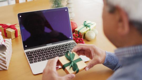 高级混血儿拿着礼物做圣诞笔记本电脑视频通话的视频，在屏幕上复制空间