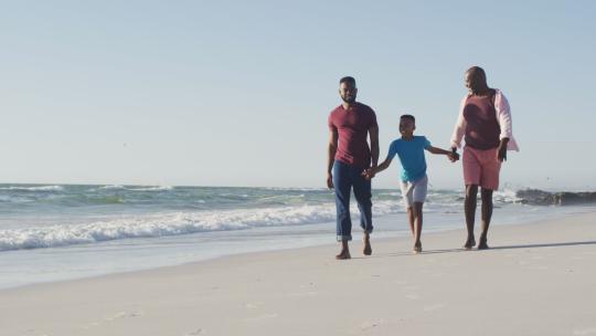 非裔美国人快乐的非裔美国人祖父，父子在海滩上散步的视频视频素材模板下载