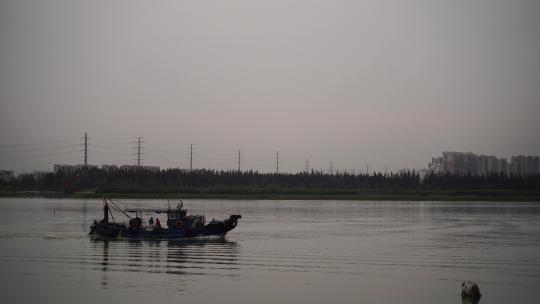 阴天傍晚长江上的渔船捕鱼船只行驶