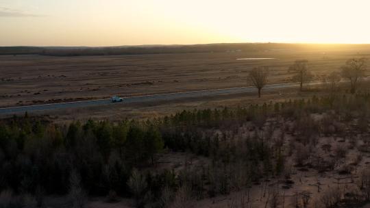 4K航拍夕阳下车辆孤独行驶在戈壁沙漠公路