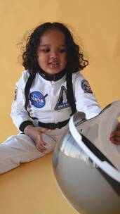 穿着美国宇航局制服转动头盔的小女孩