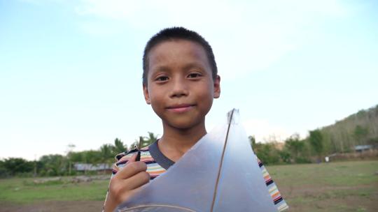 一个孩子拿着风筝微笑