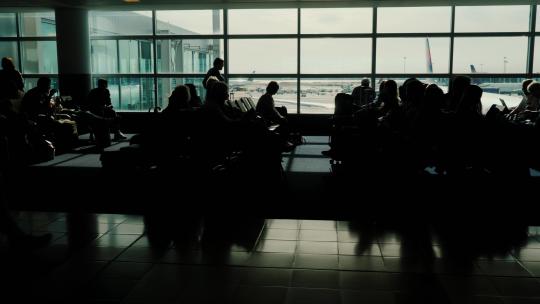 阳光透过大玻璃窗照进机场候机楼的乘客